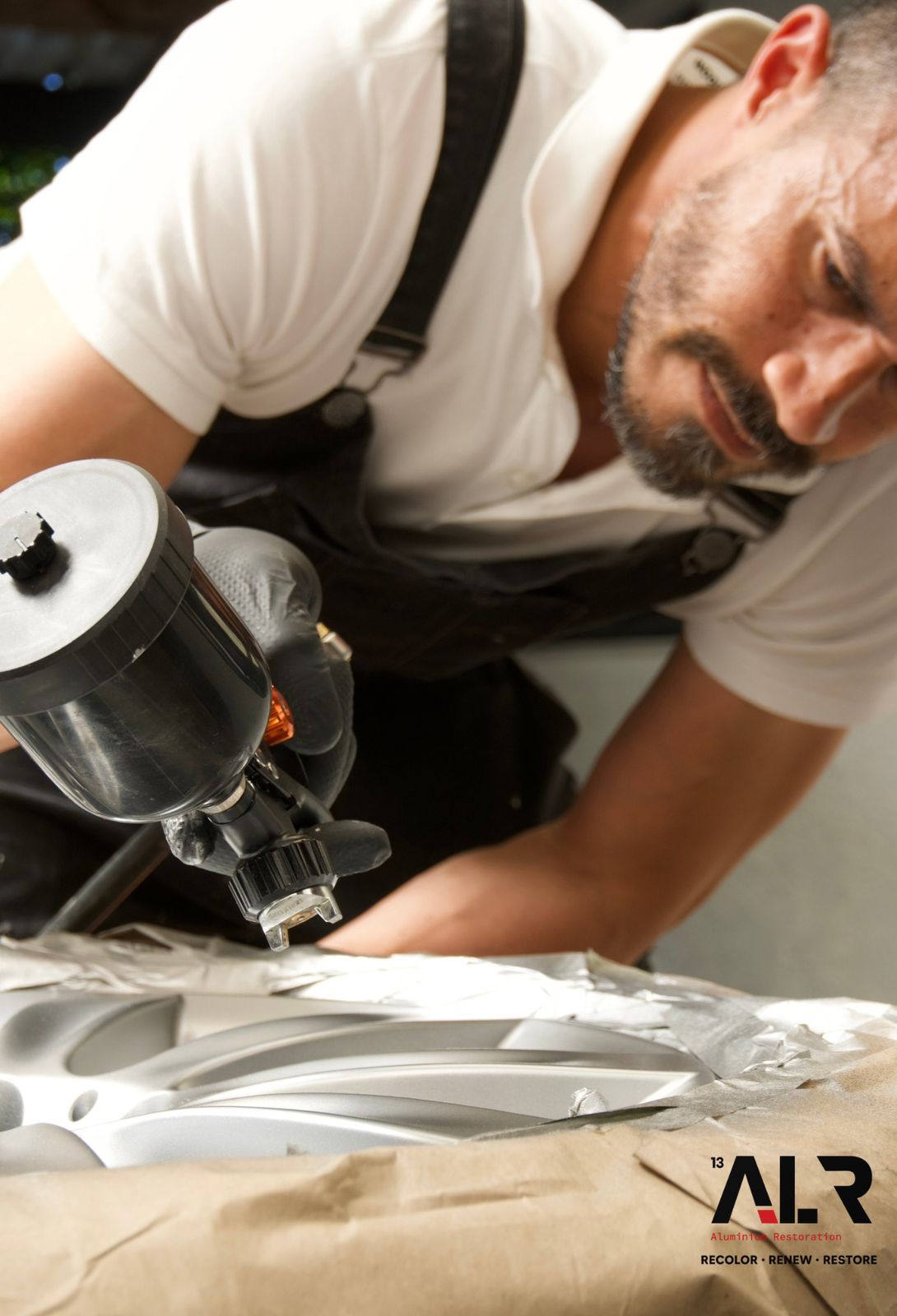 An ALR finisher spray-applying a new coat to a prepared panel in Cape Town